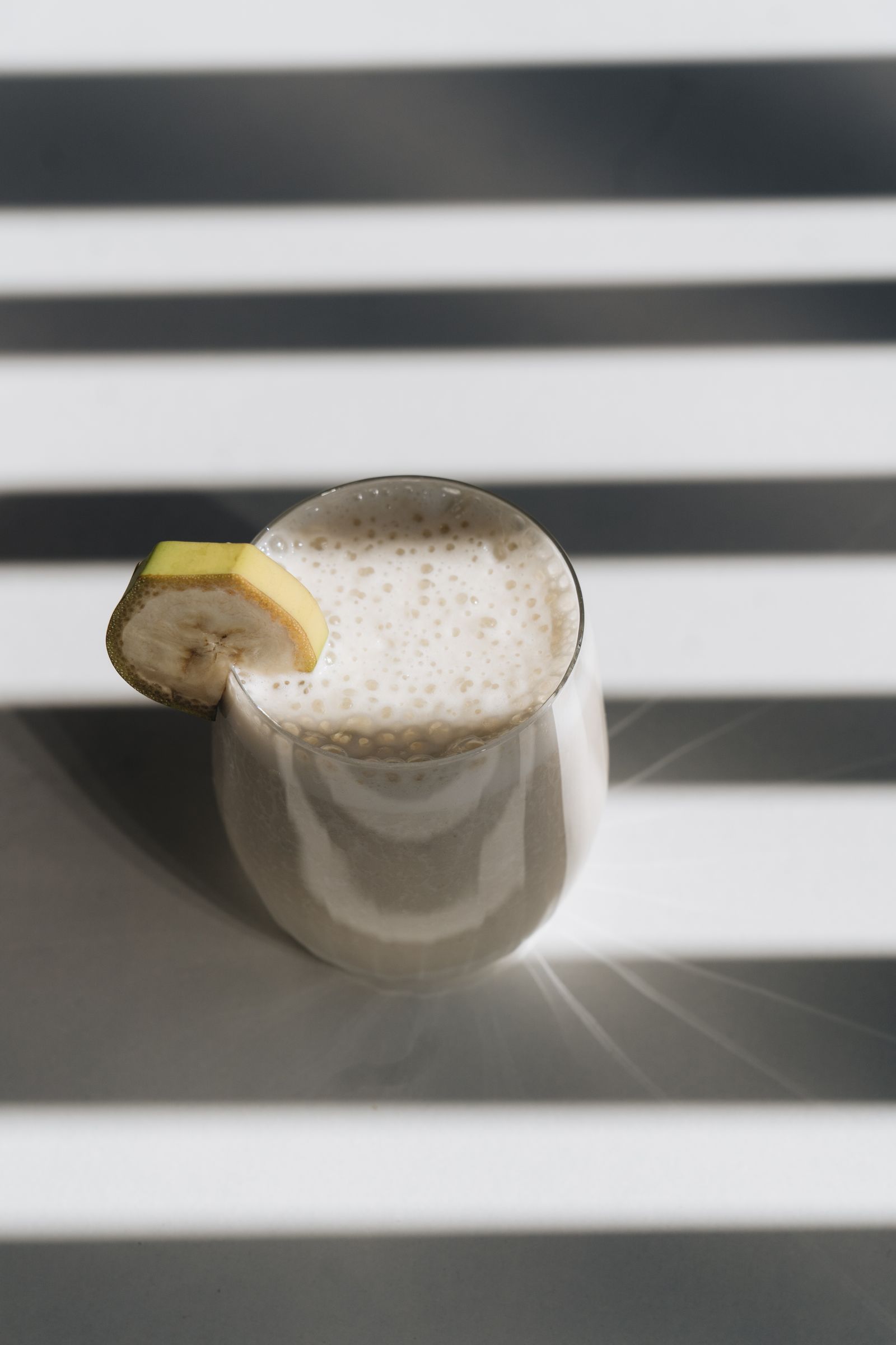 Smoothie de banana em copo de vidro com rodela de banana
